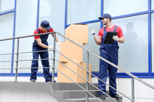 Professional movers carrying furniture through a flat stairwell