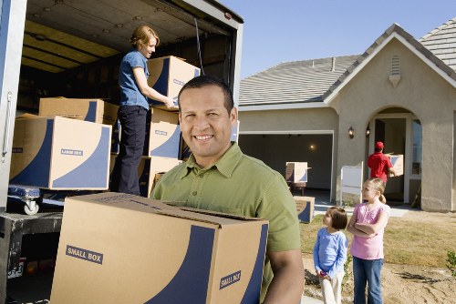 Packed boxes and furniture being loaded into a moving truck