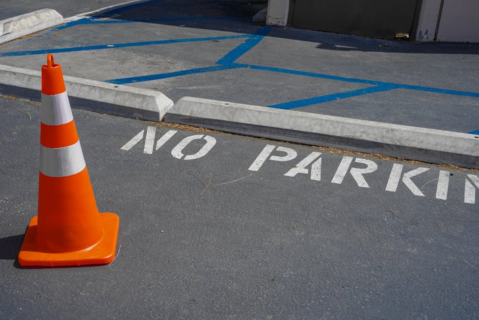 A yellow warning sign attached to a metal post reads 'WARNING Parking suspension' in black text, indicating a temporary restriction on parking. The sign is positioned outdoors near a residential stree